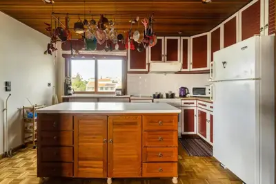 a kitchen with wooden cabinets and a white refrigerator at Elena's Athenian Penthouse in Athens