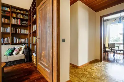 a room with bookshelves and a living room with a couch at Elena's Athenian Penthouse in Athens