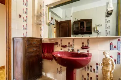 a bathroom with a red sink and a mirror at Elena's Athenian Penthouse in Athens