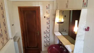 a bathroom with a mirror and a red toilet at Elena's Athenian Penthouse in Athens