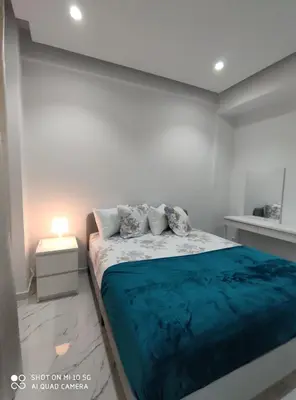 a white bedroom with a bed with a blue blanket at Modern apartment with a huge terrace in Athens