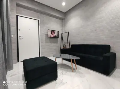 a living room with a black couch and a table at Modern apartment with a huge terrace in Athens
