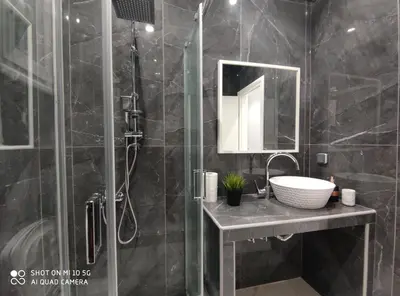 a bathroom with a shower with a sink and a mirror at Modern apartment with a huge terrace in Athens