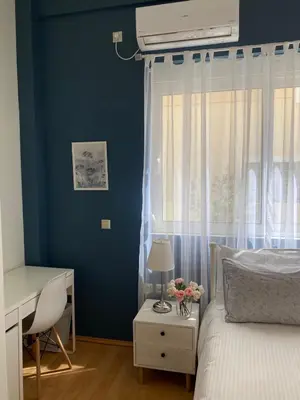 a bedroom with blue walls and a bed with a window at Elegant Glyfada Apartment-private Garden-Near METRO in Athens