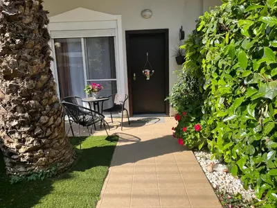 a patio with a table and chairs in front of a house at Elegant Glyfada Apartment-private Garden-Near METRO in Athens