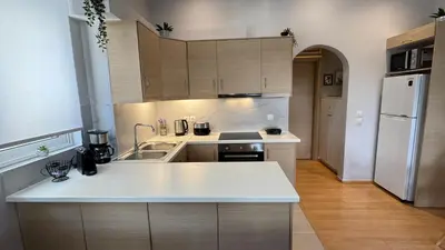 a kitchen with a white counter top and a refrigerator at Elegant Glyfada Apartment-private Garden-Near METRO in Athens