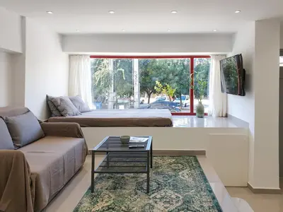 a living room with a couch and a bed at KYMA Apartments Athens 18 in Athens