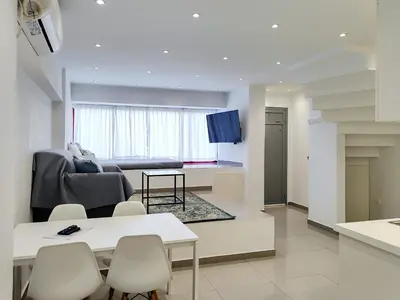 a kitchen and living room with a table and chairs at KYMA Apartments Athens 18 in Athens