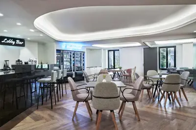 a restaurant with tables and chairs and a bar at NLH MONASTIRAKI - Neighborhood Lifestyle Hotels in Athens