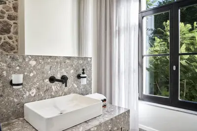 a bathroom with a white sink and a window at NLH MONASTIRAKI - Neighborhood Lifestyle Hotels in Athens
