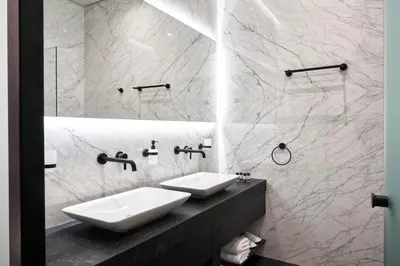 a white bathroom with two sinks and a mirror at NLH MONASTIRAKI - Neighborhood Lifestyle Hotels in Athens