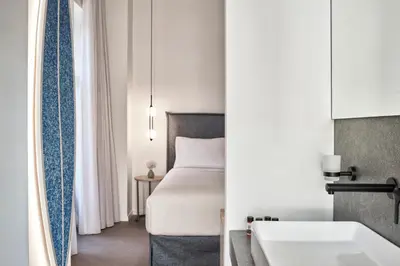 a hotel room with a bed and a sink at NLH MONASTIRAKI - Neighborhood Lifestyle Hotels in Athens