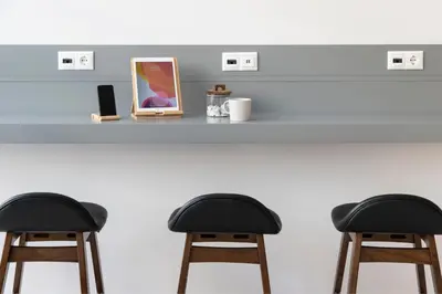 two bar stools sitting at a counter with a picture at Gallery Suites & Residences Piraeus in Piraeus