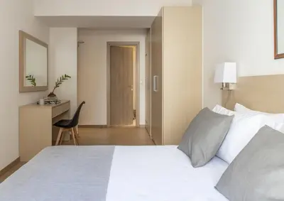 a bedroom with a bed and a desk and a chair at Gallery Suites & Residences Piraeus in Piraeus