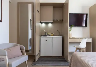 a small kitchen with a sink and a chair in a room at Gallery Suites & Residences Piraeus in Piraeus