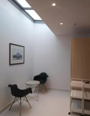 two chairs and a table in a room with a window at Gallery Suites & Residences Piraeus in Piraeus