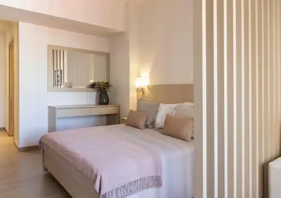 a bedroom with a large bed and a mirror at Gallery Suites & Residences Piraeus in Piraeus