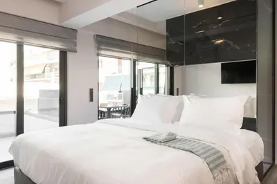 a bedroom with a large white bed with white pillows at LUX&EASY Athens Downtown Apartments in Athens