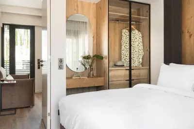 a bedroom with a white bed and a mirror at LUX&EASY Athens Downtown Apartments in Athens