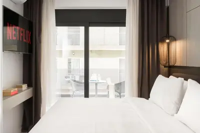 a bedroom with a bed and a view of a table at LUX&EASY Athens Downtown Apartments in Athens