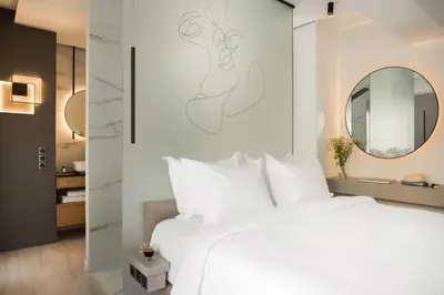 a bedroom with a white bed and a mirror at LUX&EASY Athens Downtown Apartments in Athens