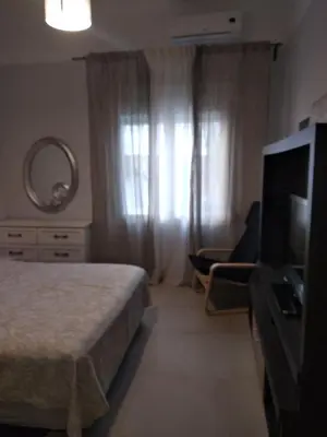 a bedroom with a bed and a flat screen tv at CENTRAL TOWN HOUSE 60m2**** in Piraeus
