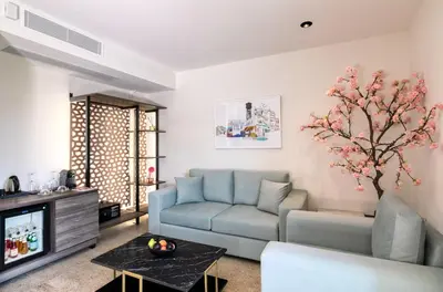 a living room with a blue couch and a tv at Athens Ivy Suites in Athens