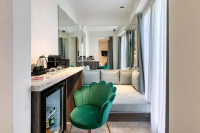 a bathroom with a green chair in a room at Athens Ivy Suites in Athens