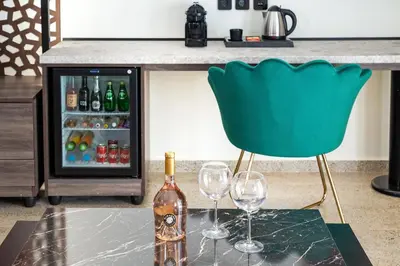 a bottle of wine and two wine glasses on a table at Athens Ivy Suites in Athens
