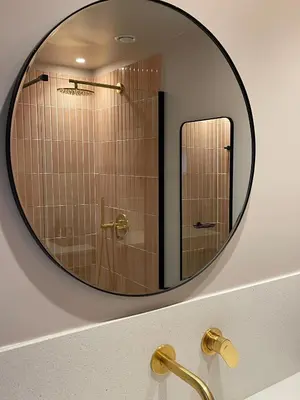 a mirror on a wall above a bathroom sink at L'Avventura Athens in Athens