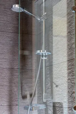 a shower with a glass door next to a wooden wall at Plaka Sweet House 2 in Athens