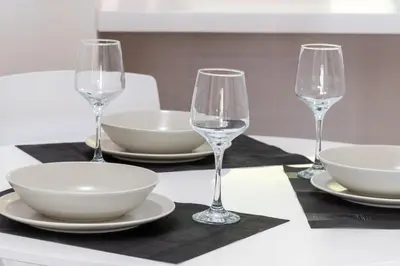 a table with three wine glasses and plates on it at Plaka Sweet House 2 in Athens