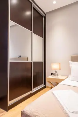 a bedroom with a large wooden closet with a bed at Plaka Sweet House 1 in Athens