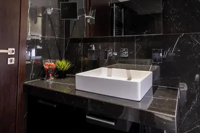 a bathroom with a white sink on a black counter at Plaka Sweet House 1 in Athens