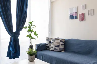 a blue couch in front of a window with a potted plant at Syntagma Sweet House in Athens