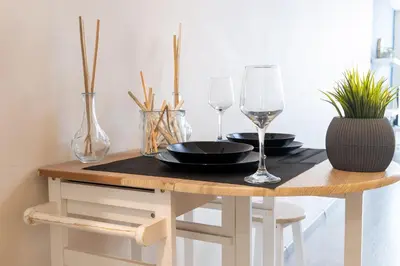 a wooden table with two wine glasses and a plate and sidx sidx sidx at Syntagma Sweet House in Athens