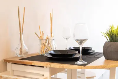 a table with two wine glasses and a black plate at Syntagma Sweet House in Athens