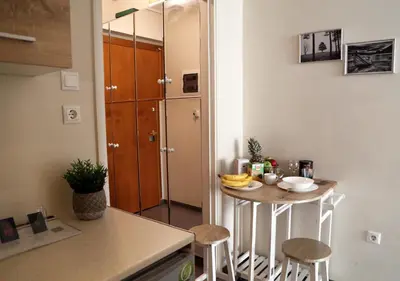 a small kitchen with a small table and stools at Syntagma Sweet House in Athens