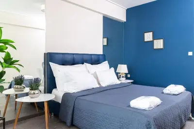 a blue bedroom with a bed and two tables at Syntagma Sweet House in Athens