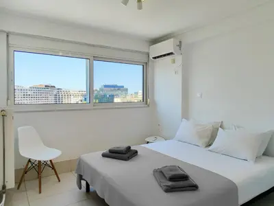 a white bedroom with a white bed and a chair at KYMA Apartments - Athens Acropolis 15 in Athens