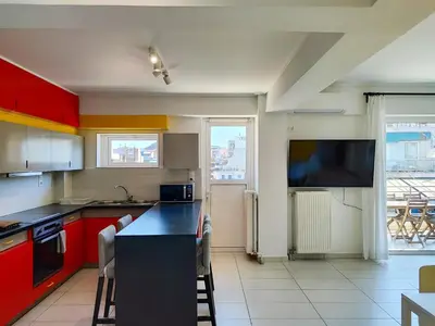 a kitchen with red cabinets and a flat screen tv at KYMA Apartments - Athens Acropolis 15 in Athens