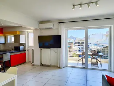 a living room with a tv and a large window at KYMA Apartments - Athens Acropolis 15 in Athens