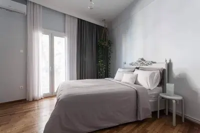 a white bedroom with a large bed and a window at Cosy flat, perfectly located in historic centre! in Athens