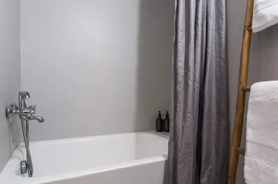 a white bath tub with a shower curtain in a bathroom at Cosy flat, perfectly located in historic centre! in Athens