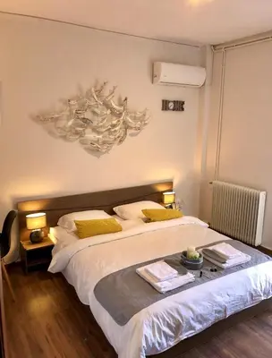 a bedroom with a large white bed with yellow pillows at Lemon Tree Inn in Markopoulo