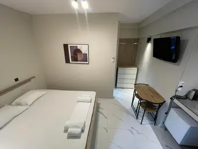 a small room with a bed and a television at Lemon Tree Inn in Markopoulo