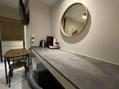 a dressing table with a mirror and a stool at Lemon Tree Inn in Markopoulo
