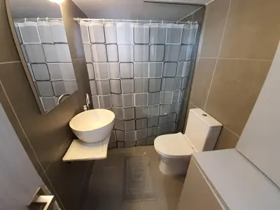 a small bathroom with a toilet and a sink at Casa Moderno near the beach in Athens