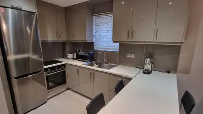 a kitchen with a stainless steel refrigerator and cabinets at Casa Moderno near the beach in Athens