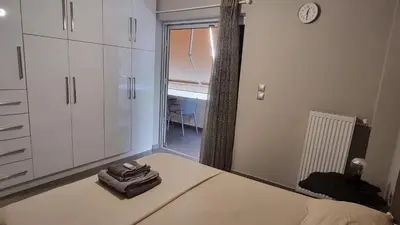 a bedroom with a bed and a window with a chair at Casa Moderno near the beach in Athens